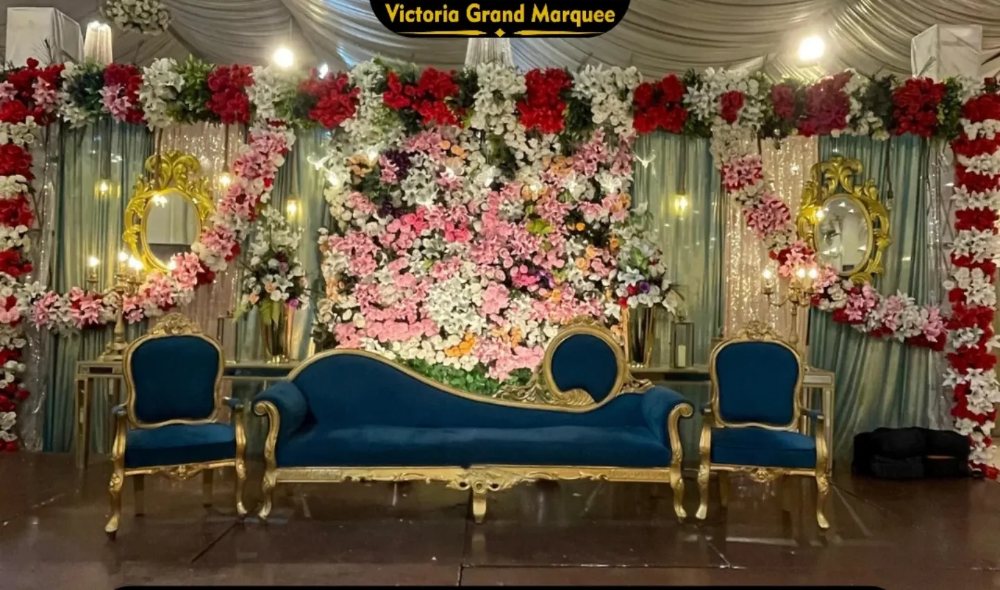 Barat stage dressed in blush blooms and warm uplighting